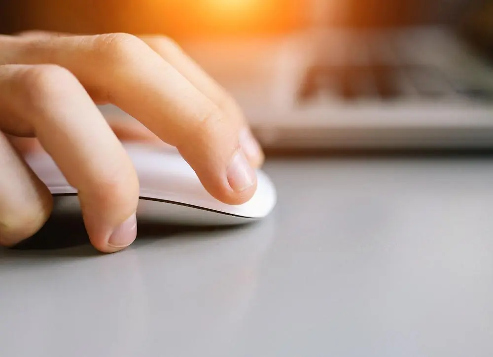 close up of hand holding computer mouse